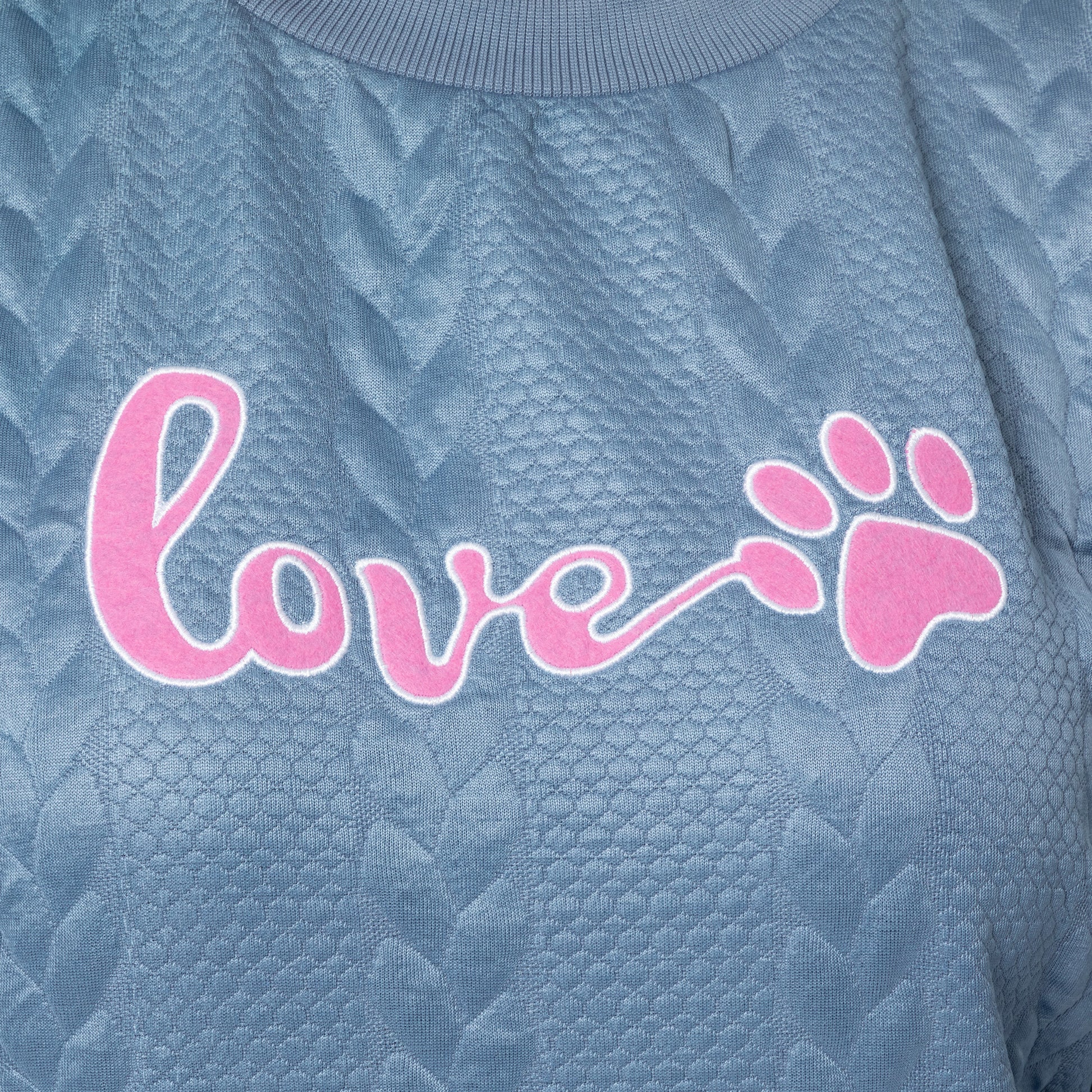 Textured blue fabric with pink 'love' and paw print design
