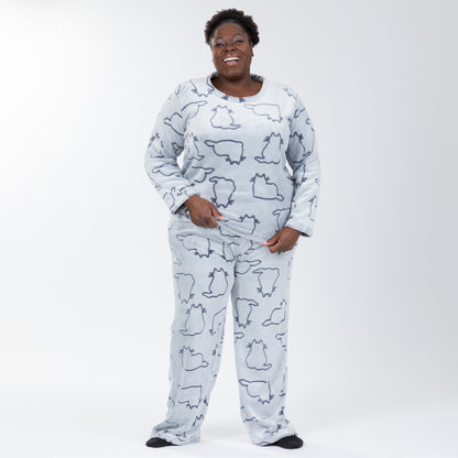 A woman wearing a matching set of fluffy, soft long-sleeve pajamas. The top and pants are light grey and patterned with cute cat outlines. Plus and extended size available.