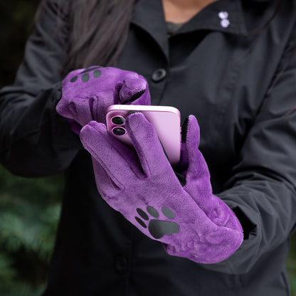 Purple gloves with paw prints holding a smartphone, worn by a person in a black jacket.