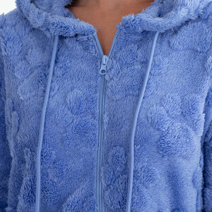 Close-up of a person wearing a plush zip-up hoodie in a dusty light blue color, showing the textured fabric, drawstrings, and zipper.