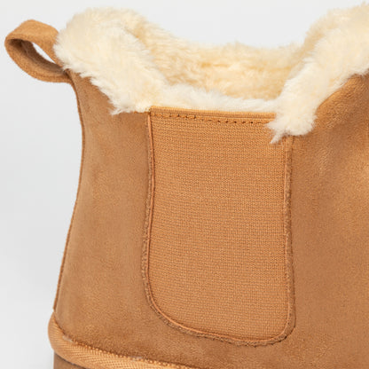 Close-up of a brown suede boot with white fur lining on a light gray background