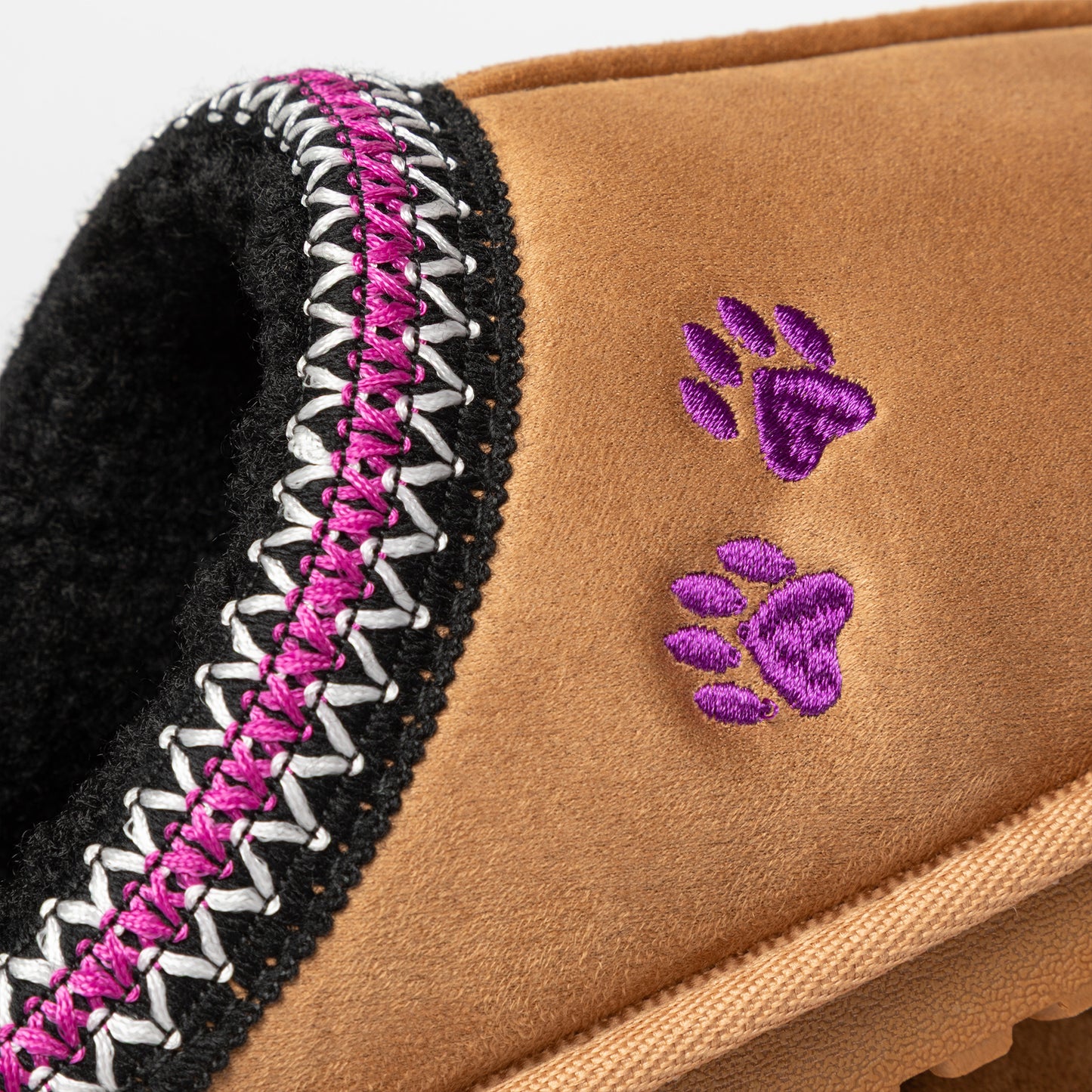 Close-up of a brown slipper with purple paw prints and a patterned trim.