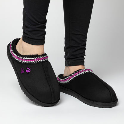 Black slipper shoes with purple and white trim worn by a person on a light gray background.