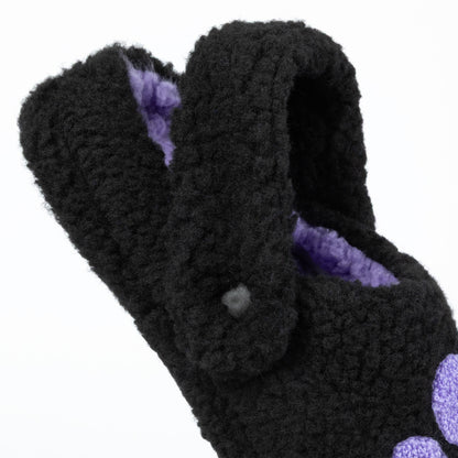 Black fuzzy slippers with purple interior on a white background