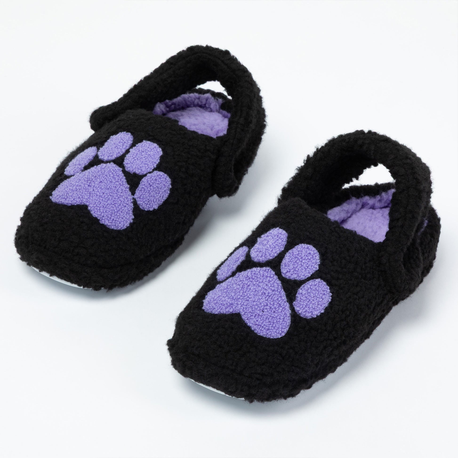 Pair of black fuzzy slippers with purple paw prints on a white background