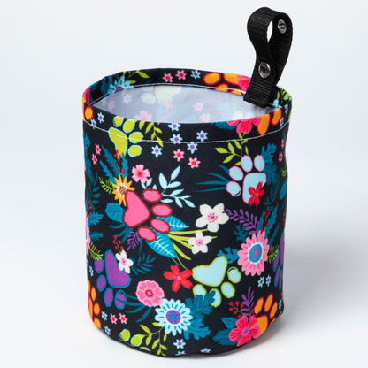 Colorful floral-patterned fabric container with a black handle on a white background