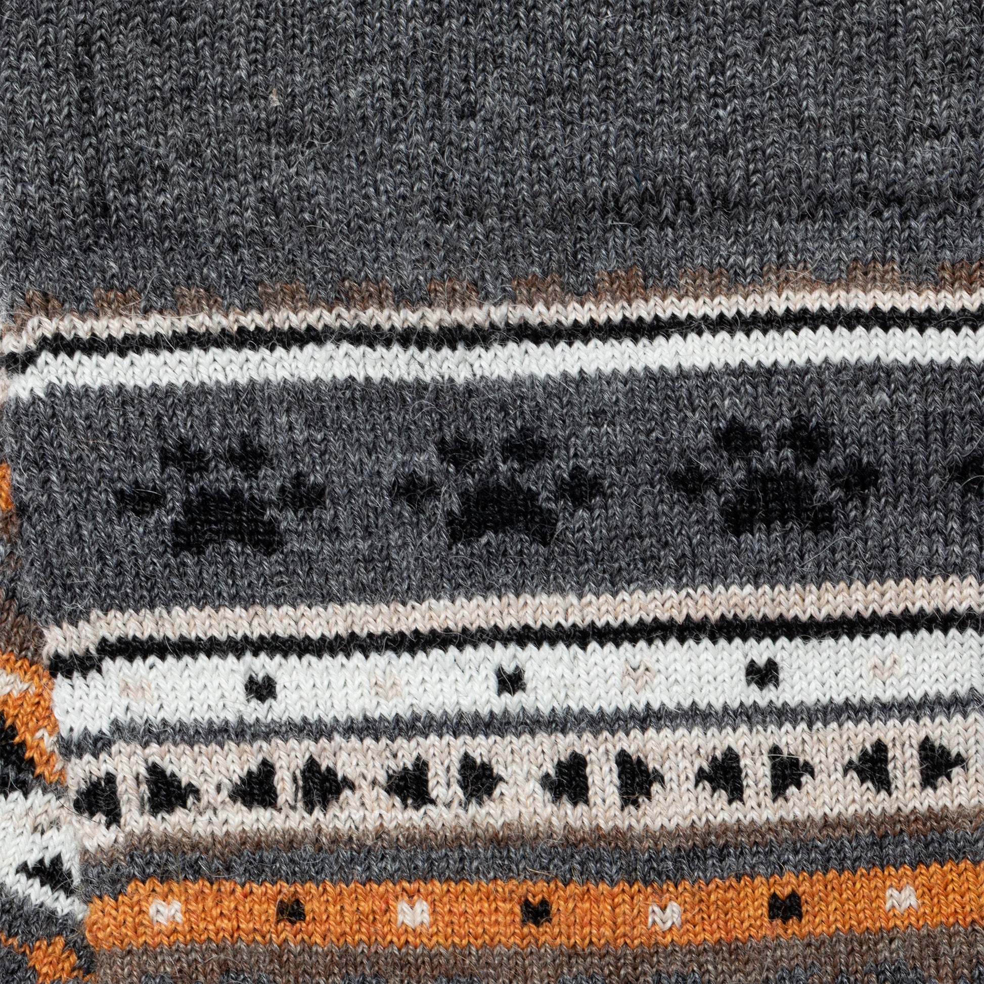Close-up of a knitted fabric with a pattern featuring black paw prints on a gray background.