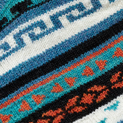 Close-up of a woven pattern with blue, white, black, and orange colors.