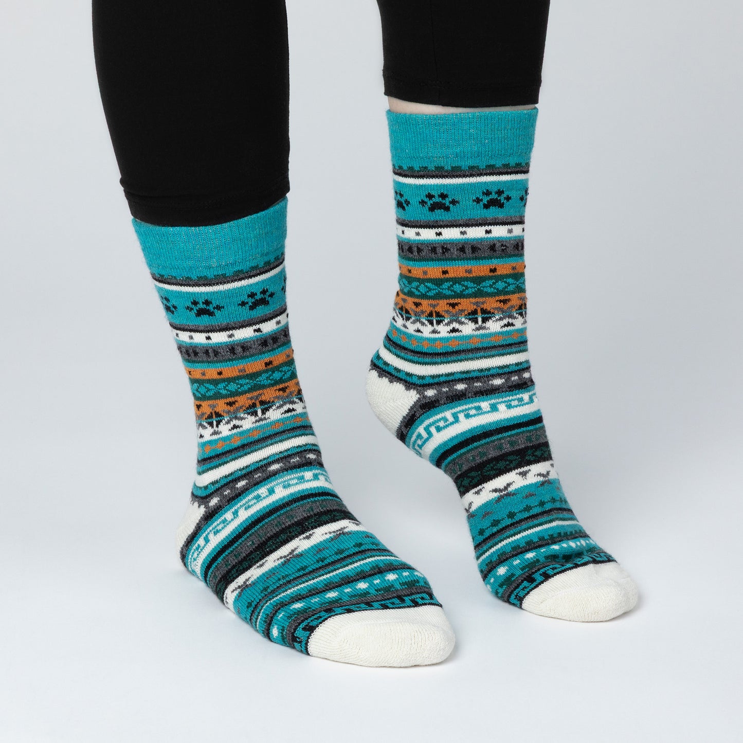 Colorful patterned socks worn with black leggings on a light gray background