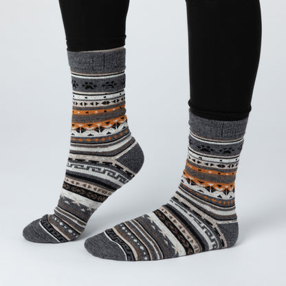 Patterned socks worn with black pants on a light gray background