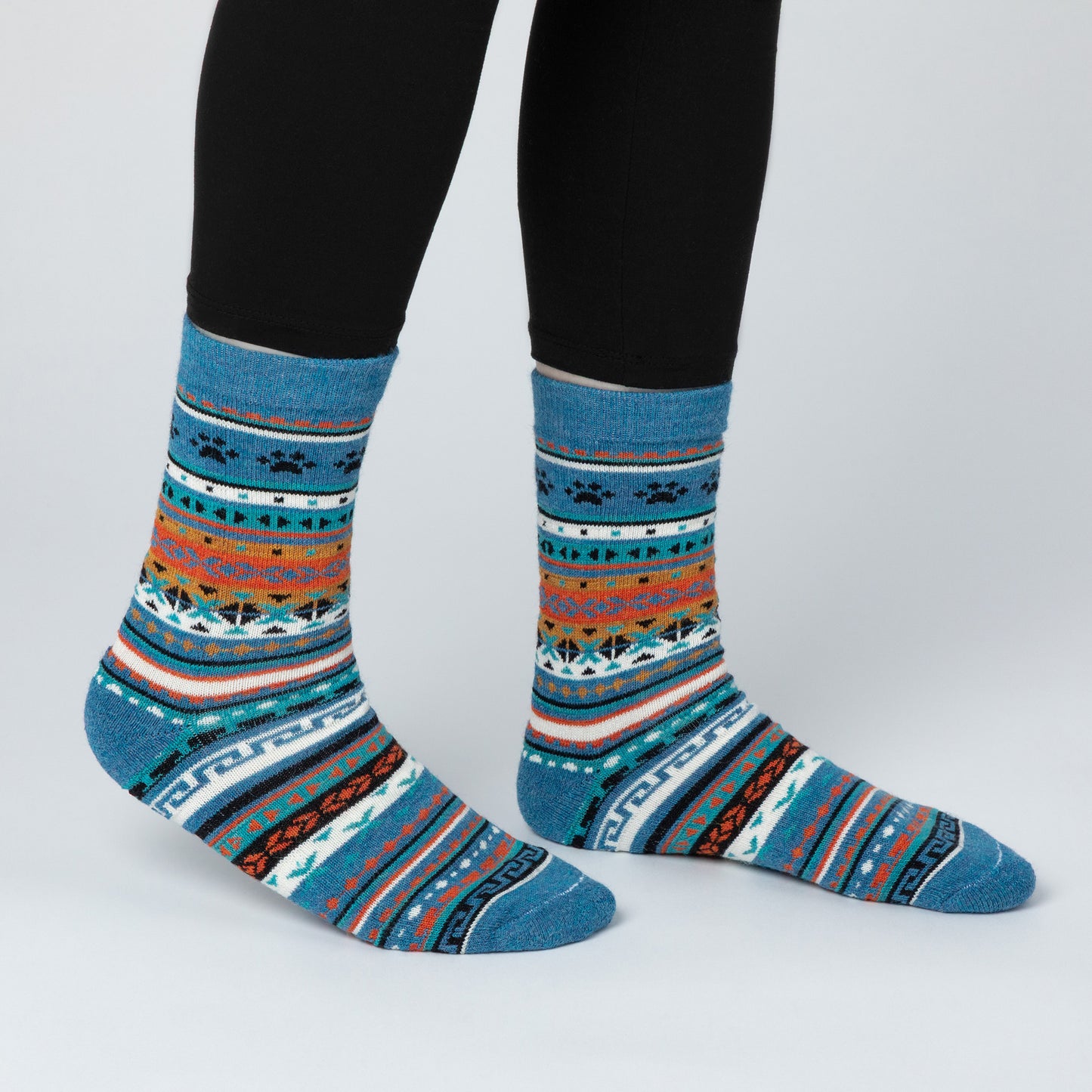 Colorful patterned socks worn with black leggings on a light gray background