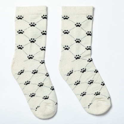 Pair of cream socks with black paw print pattern on a light gray background