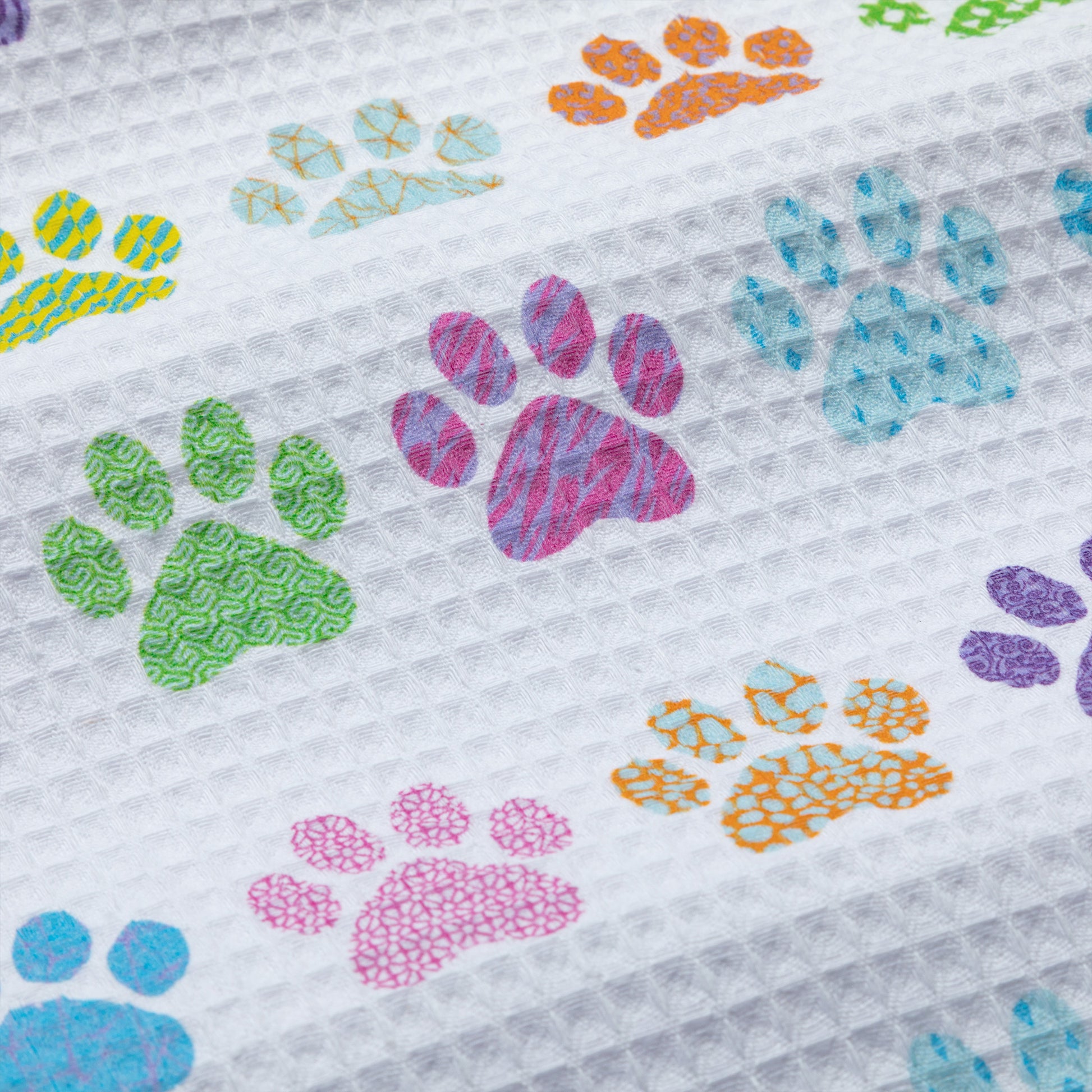 Close up of colorful paw prints on a textured dish towel