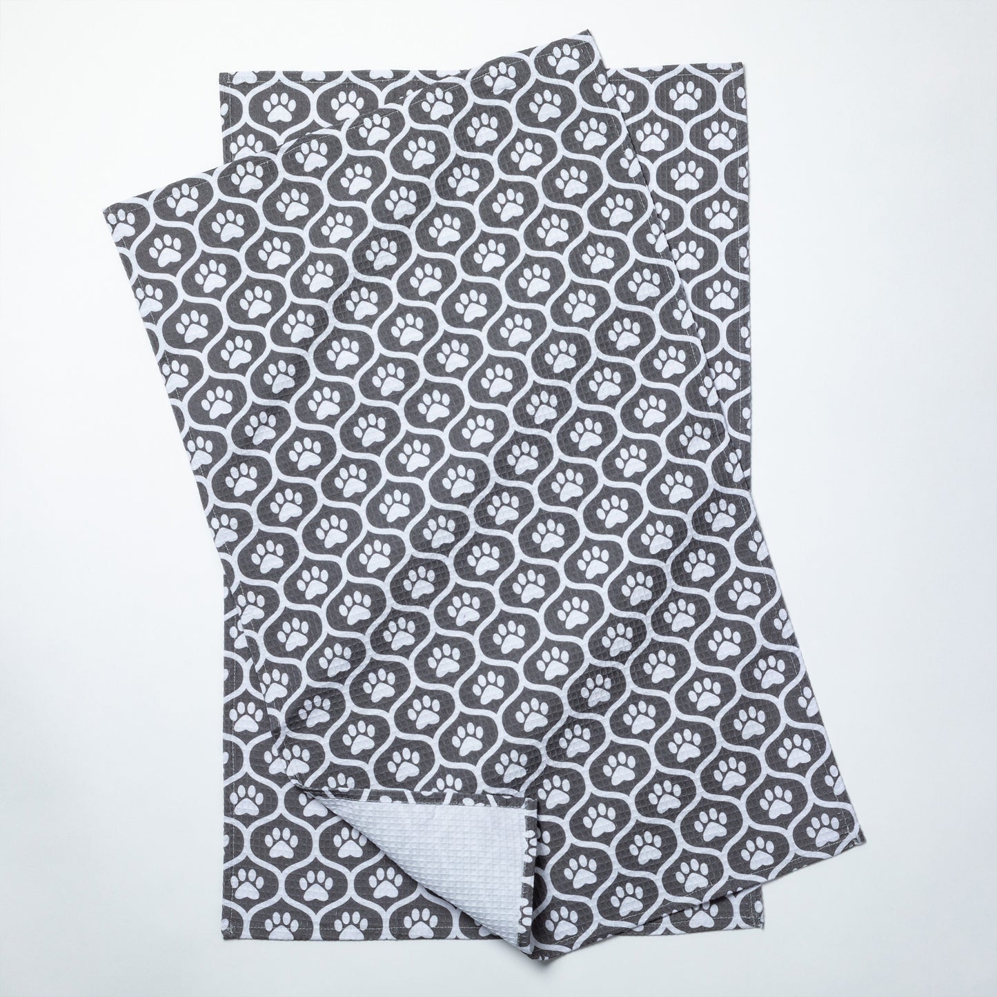 Folded fabric with gray paw print pattern on a white background