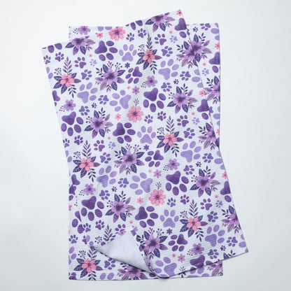 Floral patterned dish towels with purple and pink flowers and paws on a white background