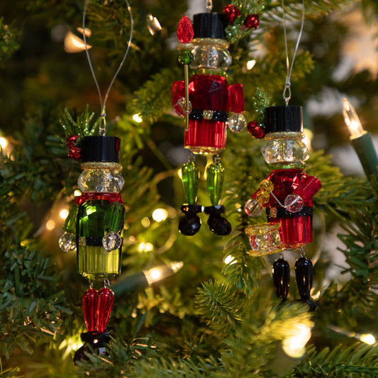 Decorative Christmas ornaments shaped like soldiers hanging on a tree.