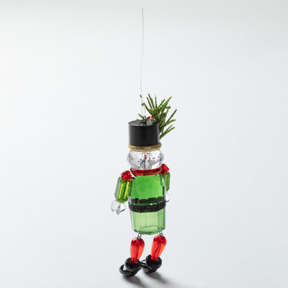 nutcracker ornament with black top hat and sparkly holly in the hat with a green body