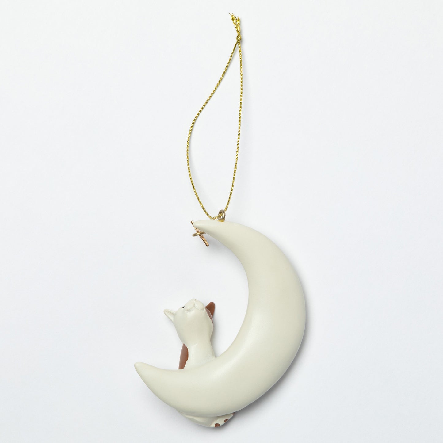 Decorative ornament of a cat lying on a crescent moon with a gold chain on a light gray background