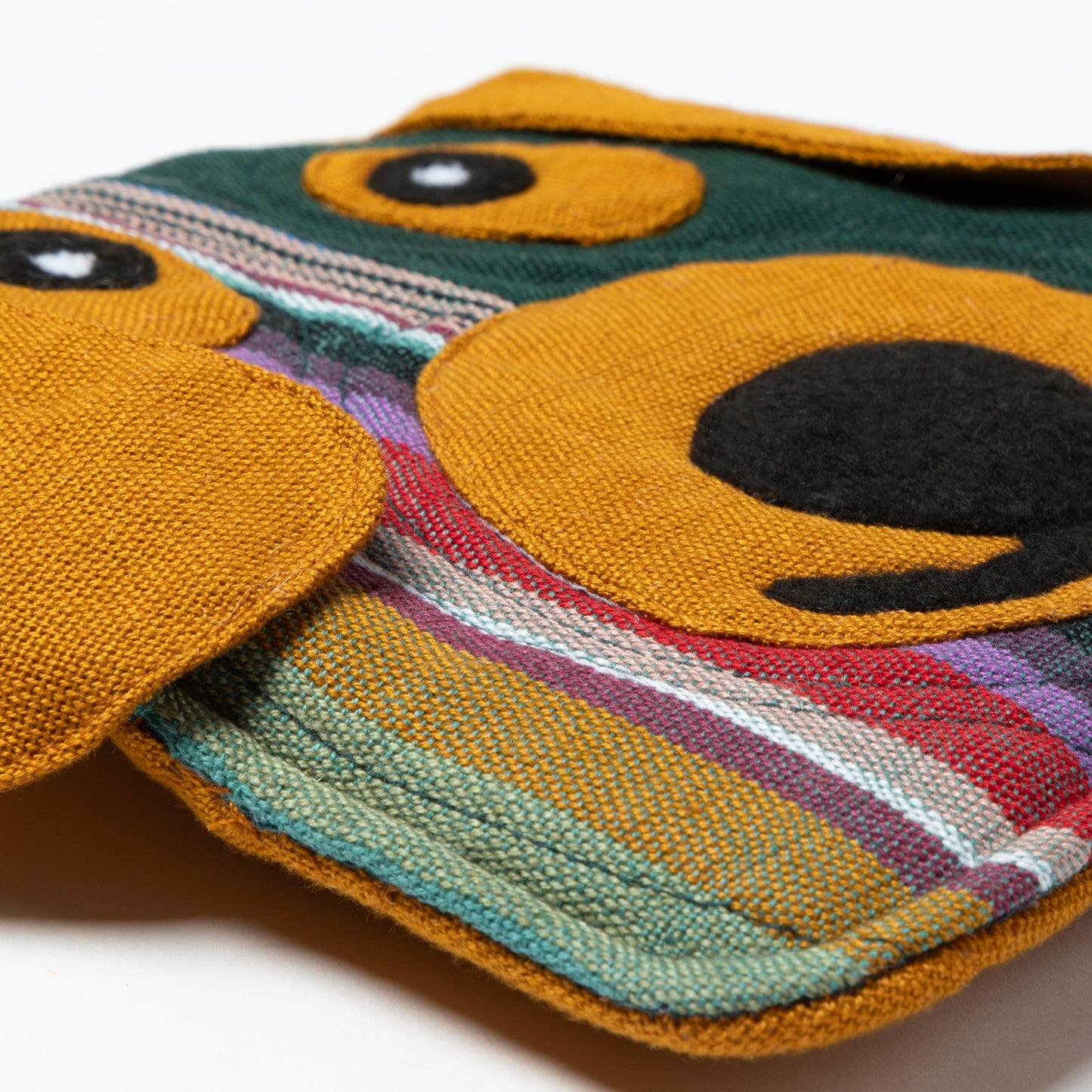 Colorful woven pot holder with geometric pattern on a white background