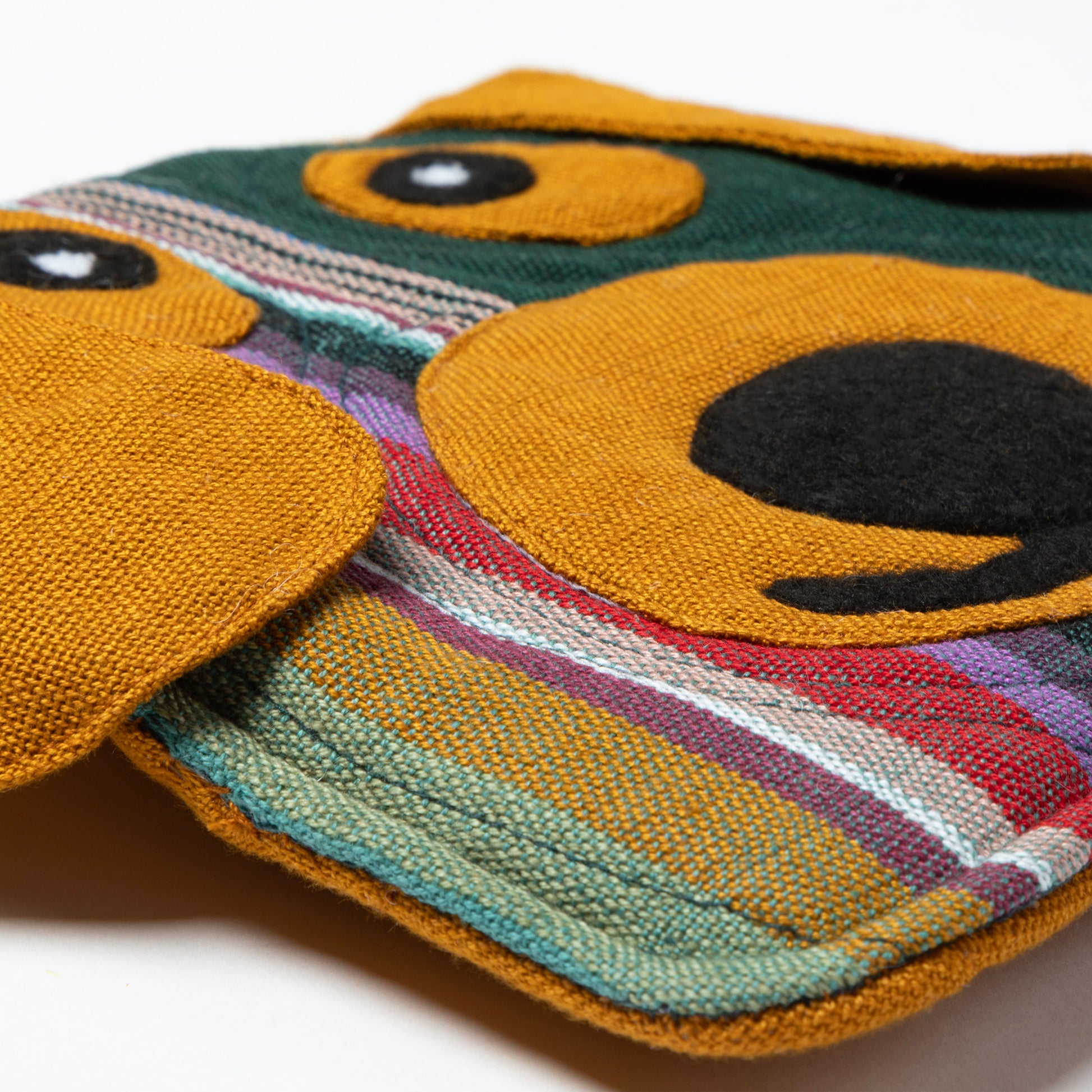 Colorful woven pot holder with geometric pattern on a white background