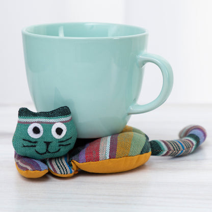 Colorful cat-shaped tea coaster next to a light blue mug on a white background