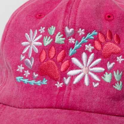 Pink cap with floral and paw print embroidery on a white background
