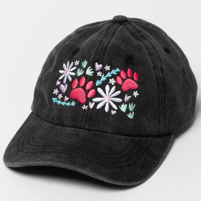 Black cap with floral and paw print design on a light gray background