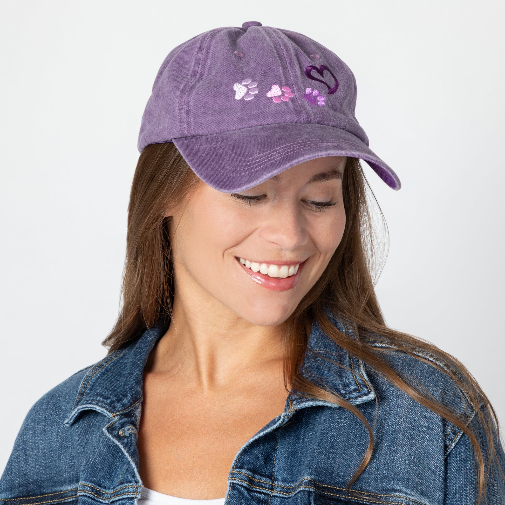 Woman wearing a purple cap with paw prints on a white background