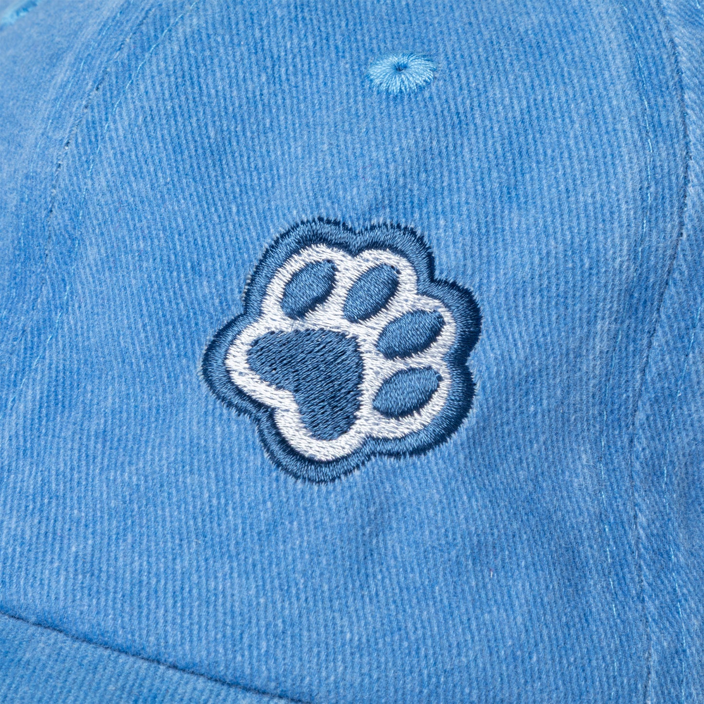 Blue baseball cap with navy blue paw print embroidered on the front