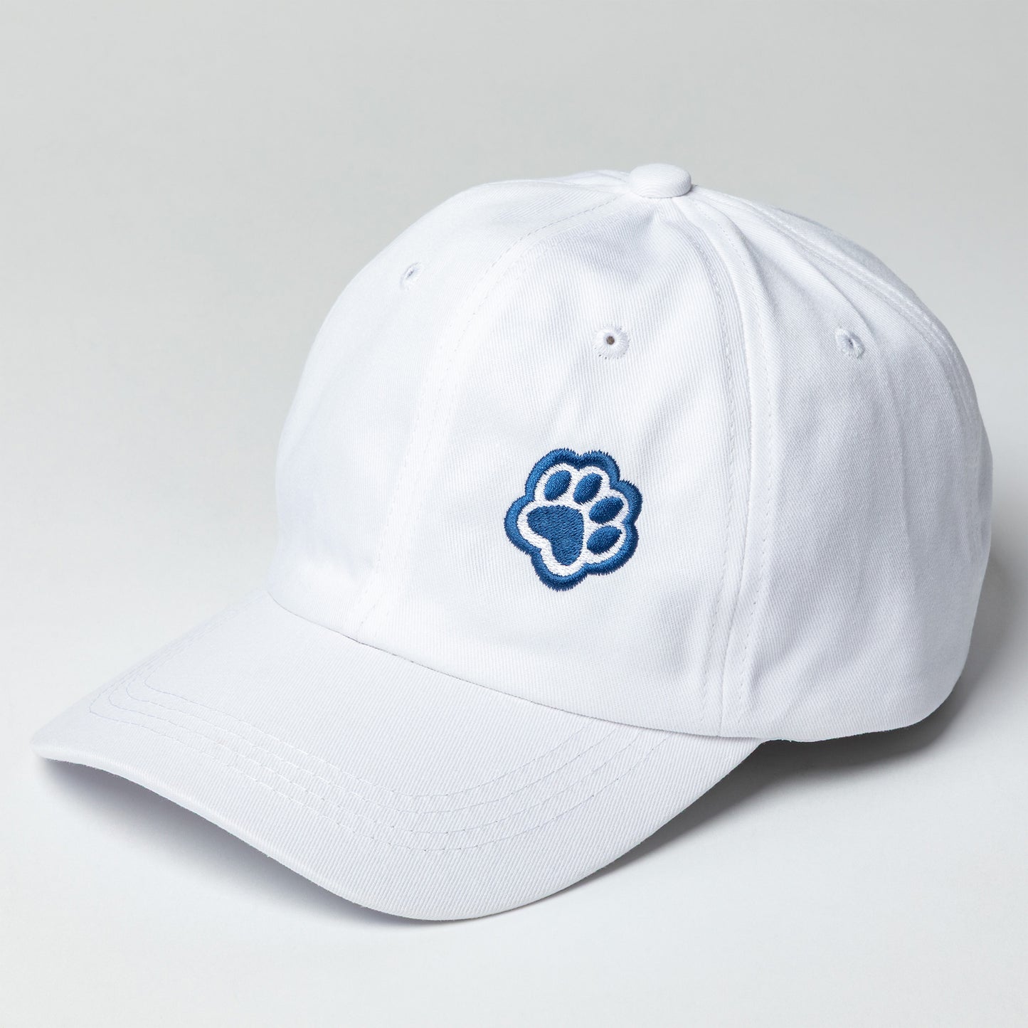 White baseball cap with navy blue paw print embroidered on the front