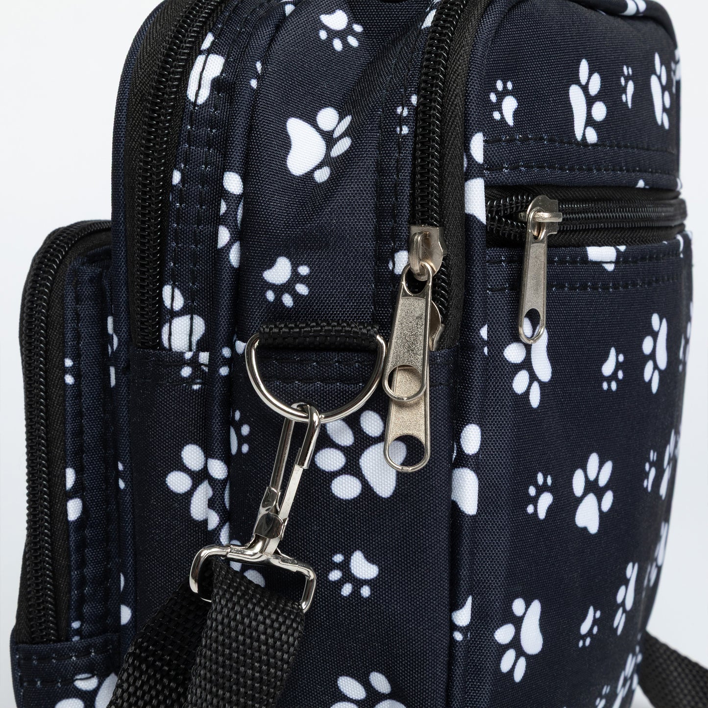 Black bag with white paw prints and a metal clasp on a white background