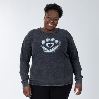 Woman wearing a dark gray long-sleeve shirt with a heart design on a white background