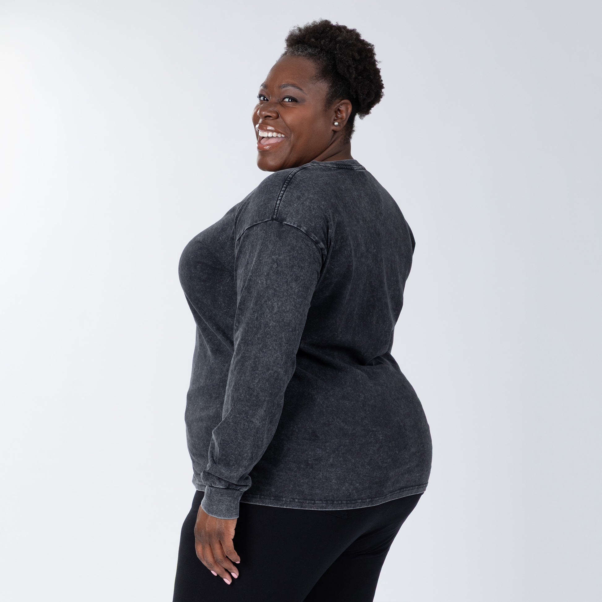 Woman wearing a dark gray long-sleeve shirt on a white background