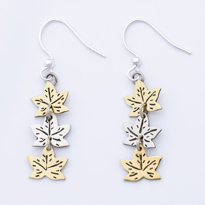 Pair of earrings with leaf-shaped charms on a white background