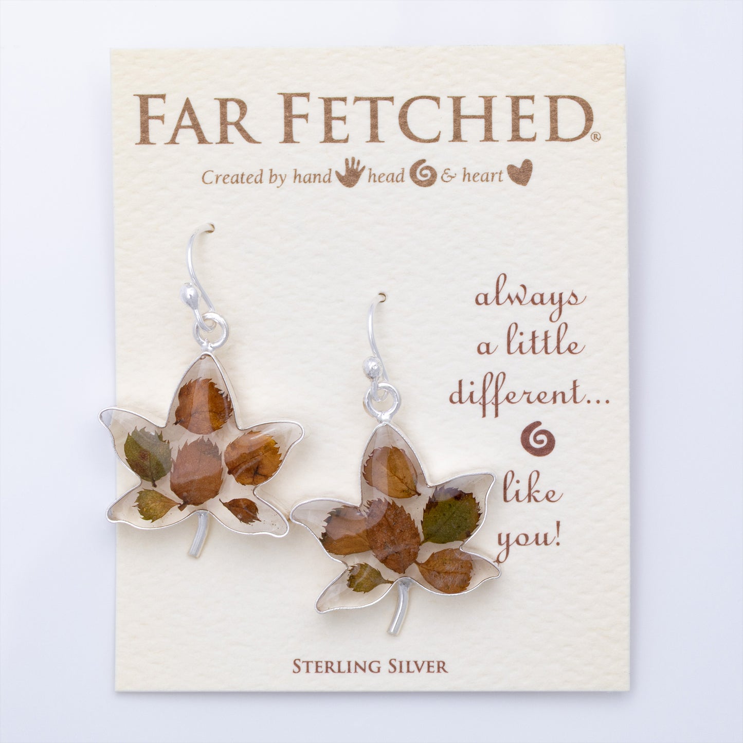 Maple leaf-shaped earrings on a 'Far Fetched' branded card with text.