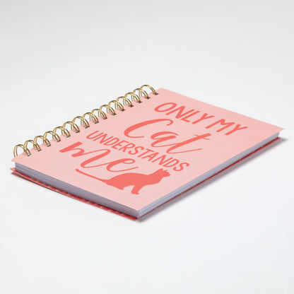 Pink notebook with 'Only my cat understands me' text and cat illustration on a white background