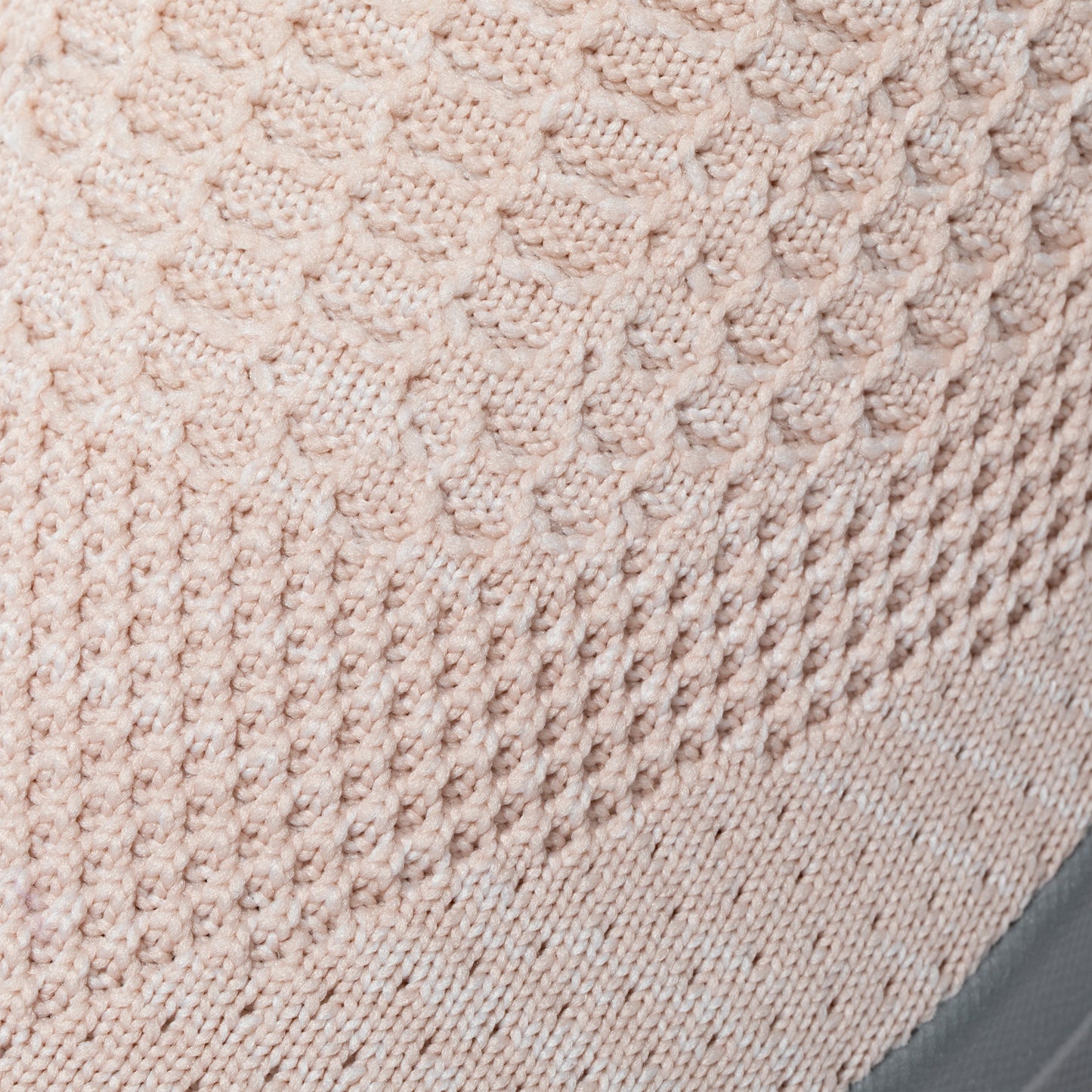 Close-up of light pink textured knitted breathable upper fabric of sneaker.