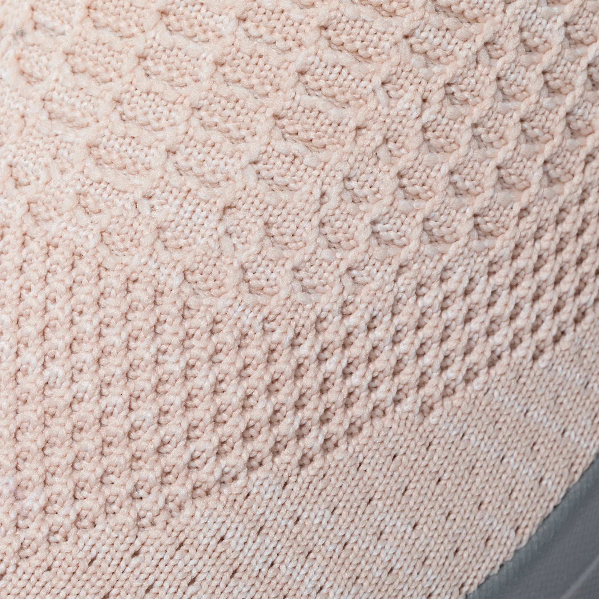 Close-up of light pink textured knitted breathable upper fabric of sneaker.