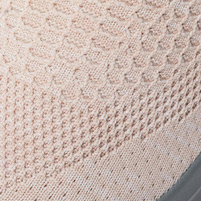 Close-up of light pink textured knitted breathable upper fabric of sneaker.