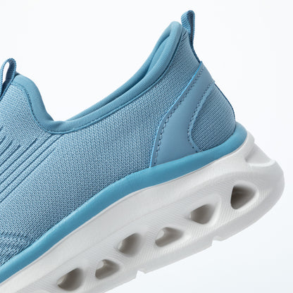 Blue athletic shoe with a white shock absorbing sole on a light gray background