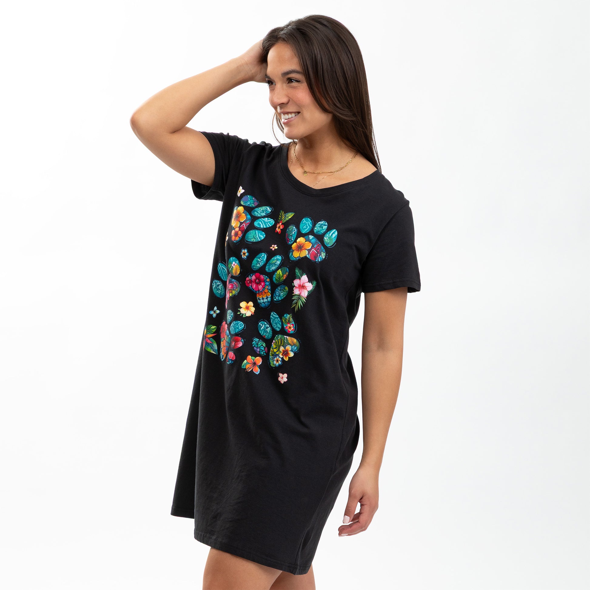 Woman wearing a black nightgown with colorful floral design on a white background