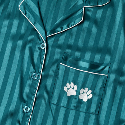 Teal satin pajama top with white paw prints on a striped background