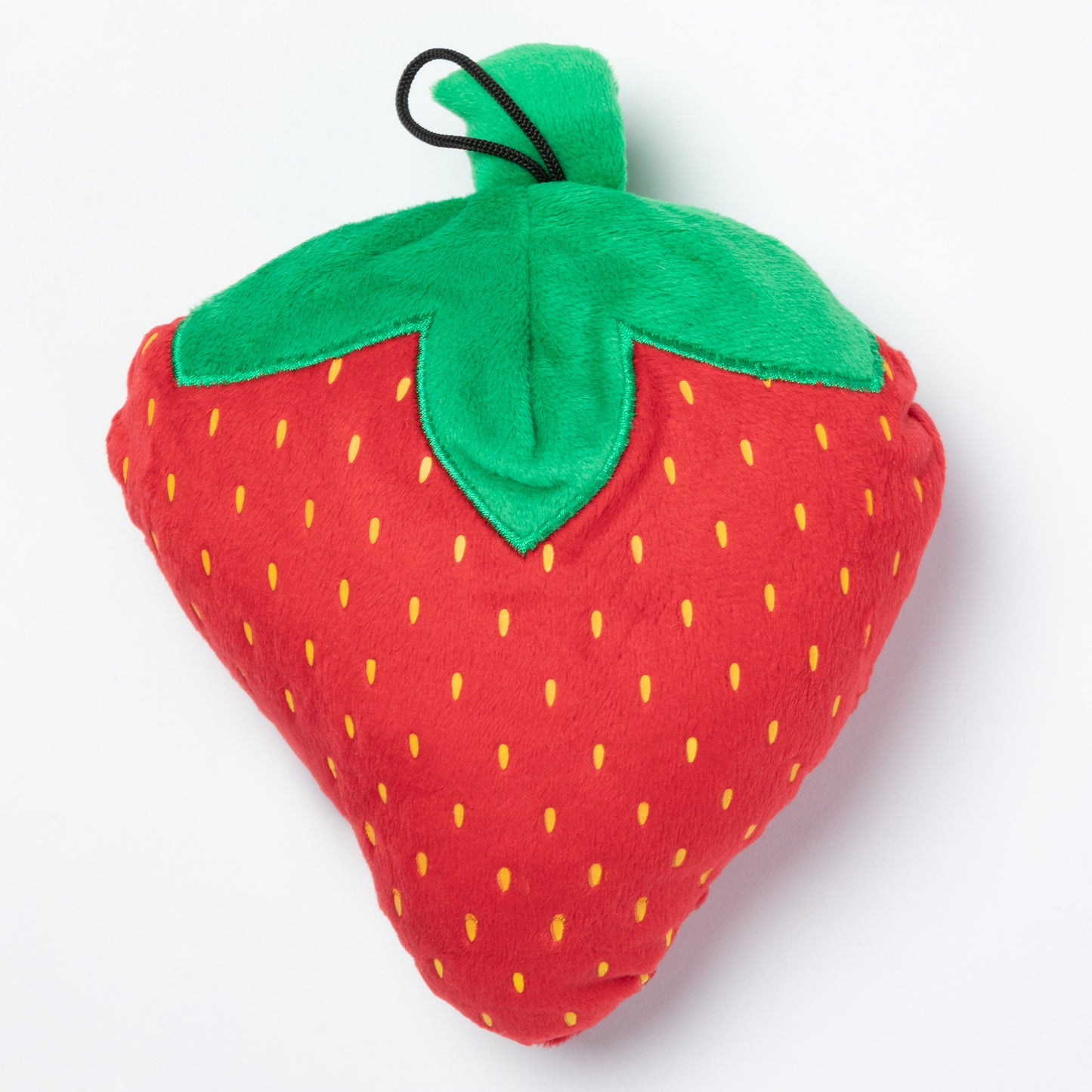 Plush strawberry dog toy with green stem on a white background
