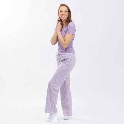 Woman wearing a purple tee and light purple rib knit relaxed fit pants on a white background.