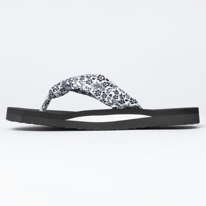 Black sandal with a white floral pattern on a light gray background