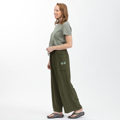 Woman wearing a green outfit with wide-leg pants on a white background