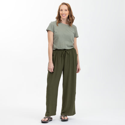 Woman wearing a green top and matching pants on a white background
