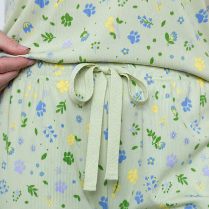Light green fabric with floral pattern held by a hand