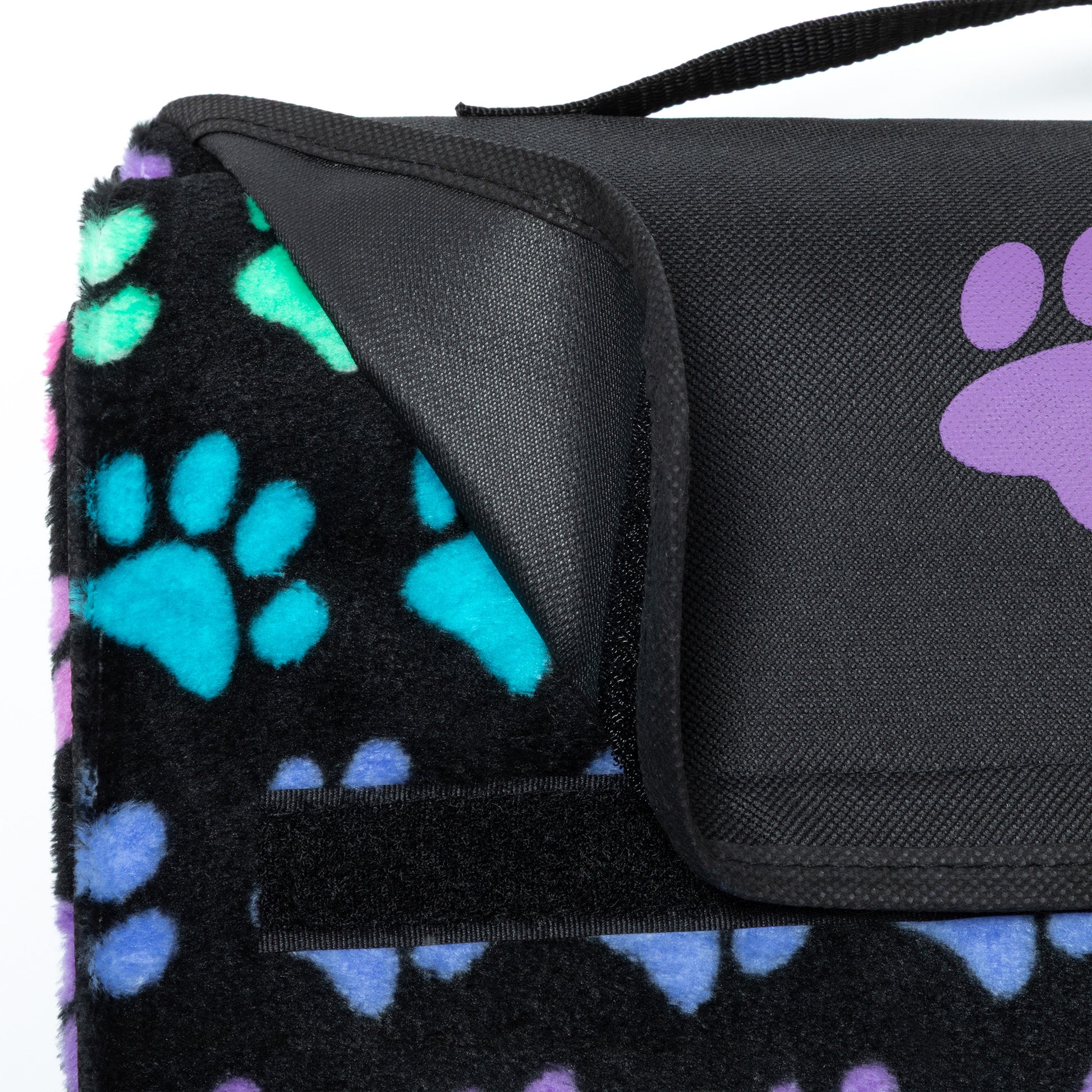 Black blanket with colorful paw prints and a black folding top with handle.