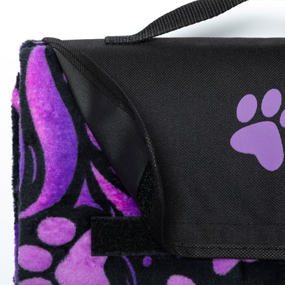 Black and purple paw print blanket with a strap on a white background.